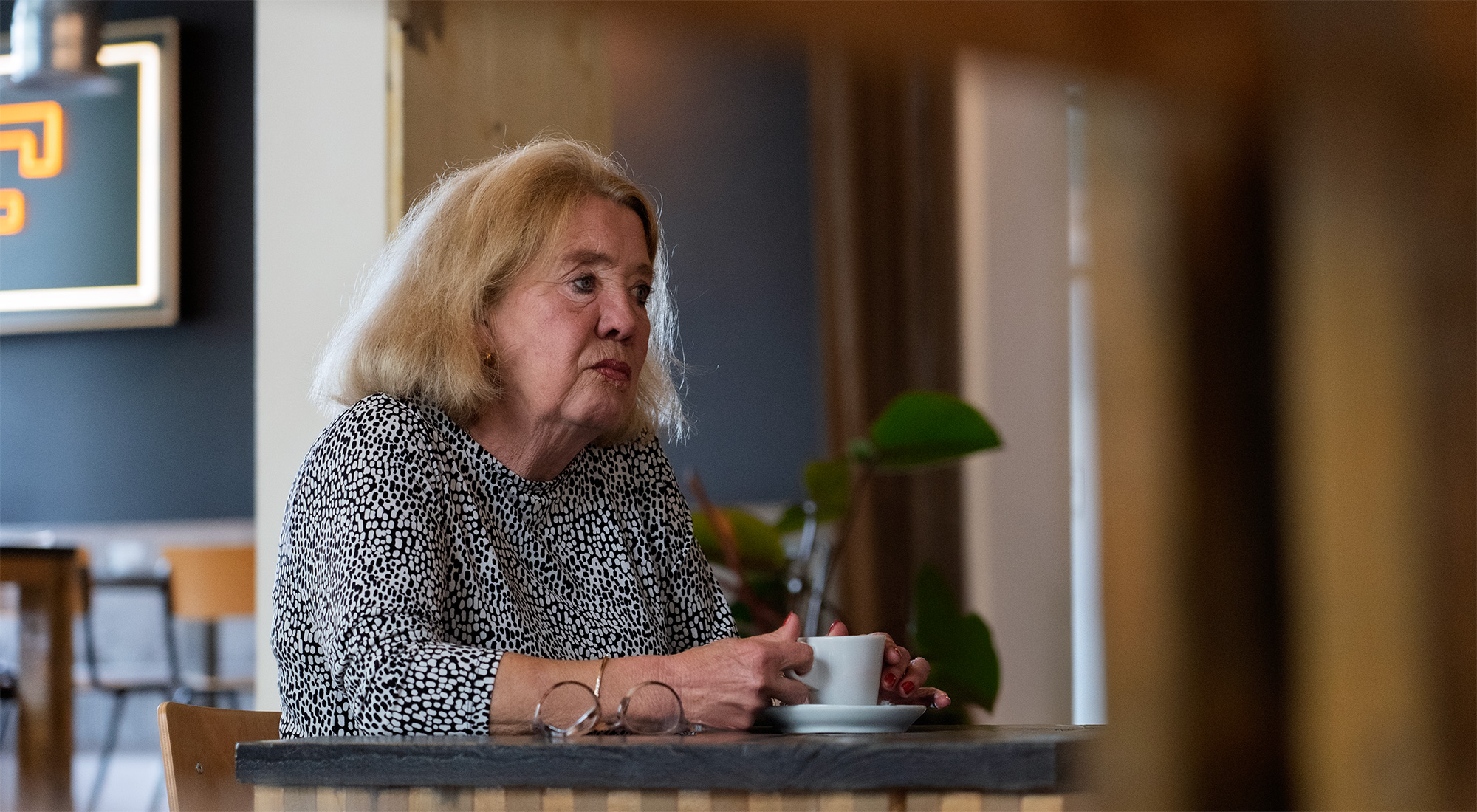 Marike zit aan tafel met een kopje koffie